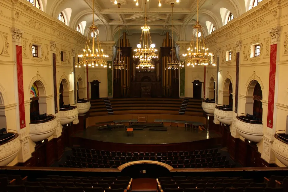 A balcony view over the seating, stage and organ inside Cape Town City Hall.