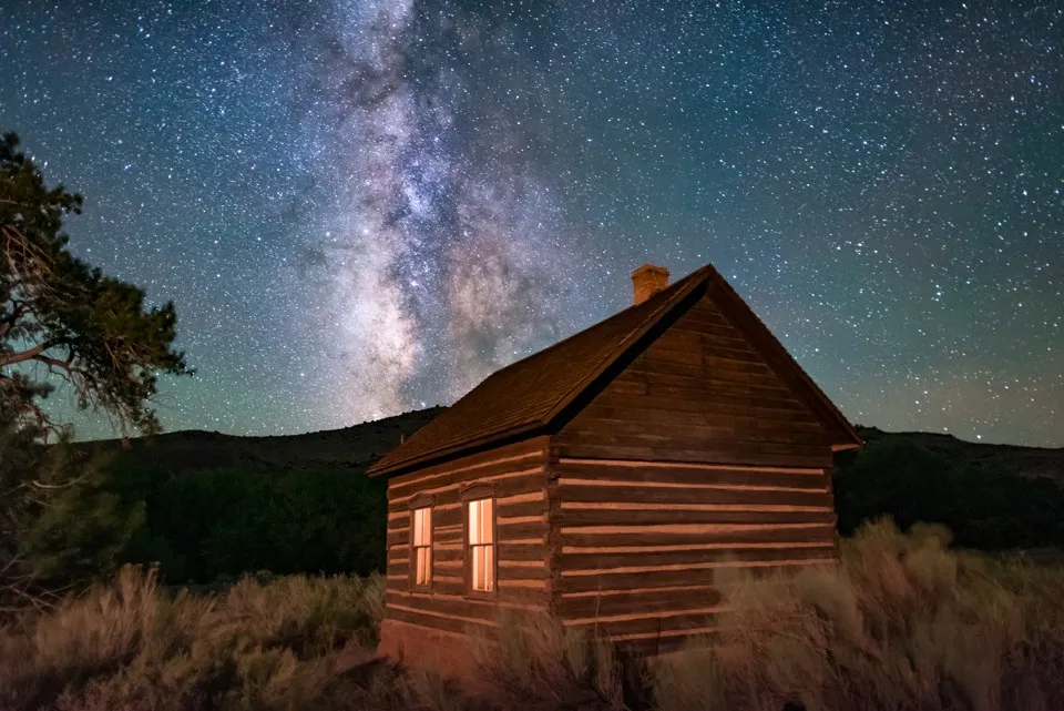 A small wooden schoolhouse beneath the Milky Way in Fruita, Utah.
