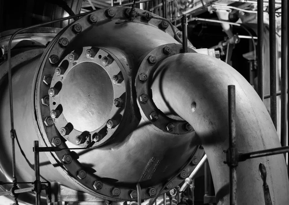 Black-and-white close view of a large steam condenser and pipes at the historic Boston waterworks.