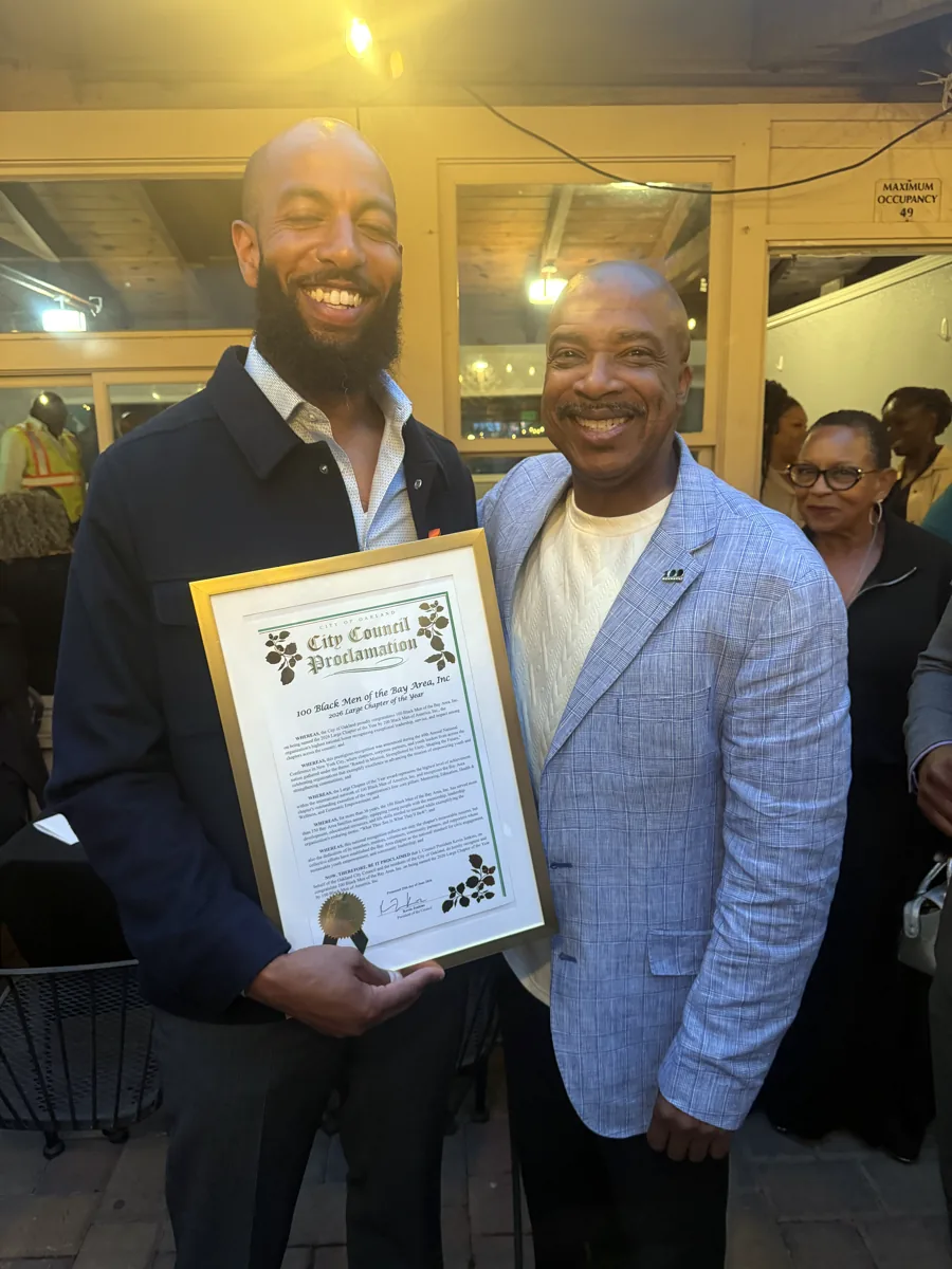 Hisham holding an Oakland City Council proclamation recognizing 100 Black Men of the Bay Area